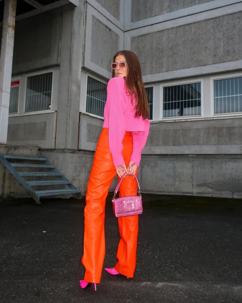 Foto da Blogueira Nina S com um look todo colorido no laranja da temporada.