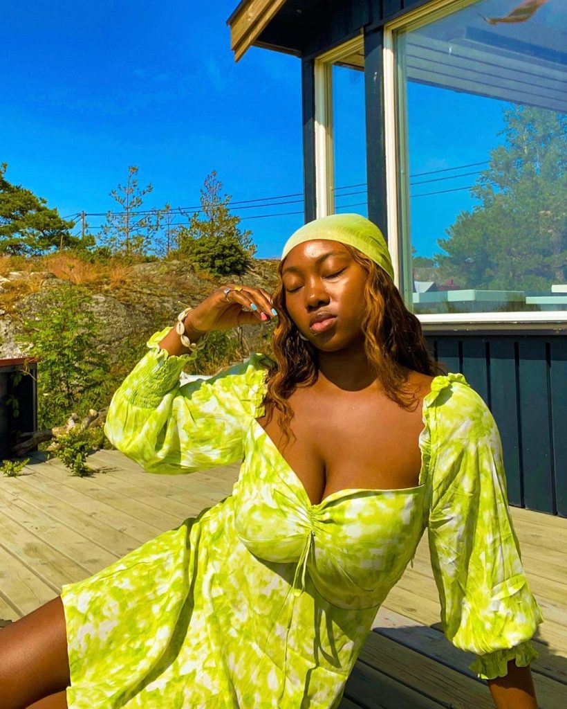 Foto da influenciadora Nnenna com um vestido estampado verde lima.