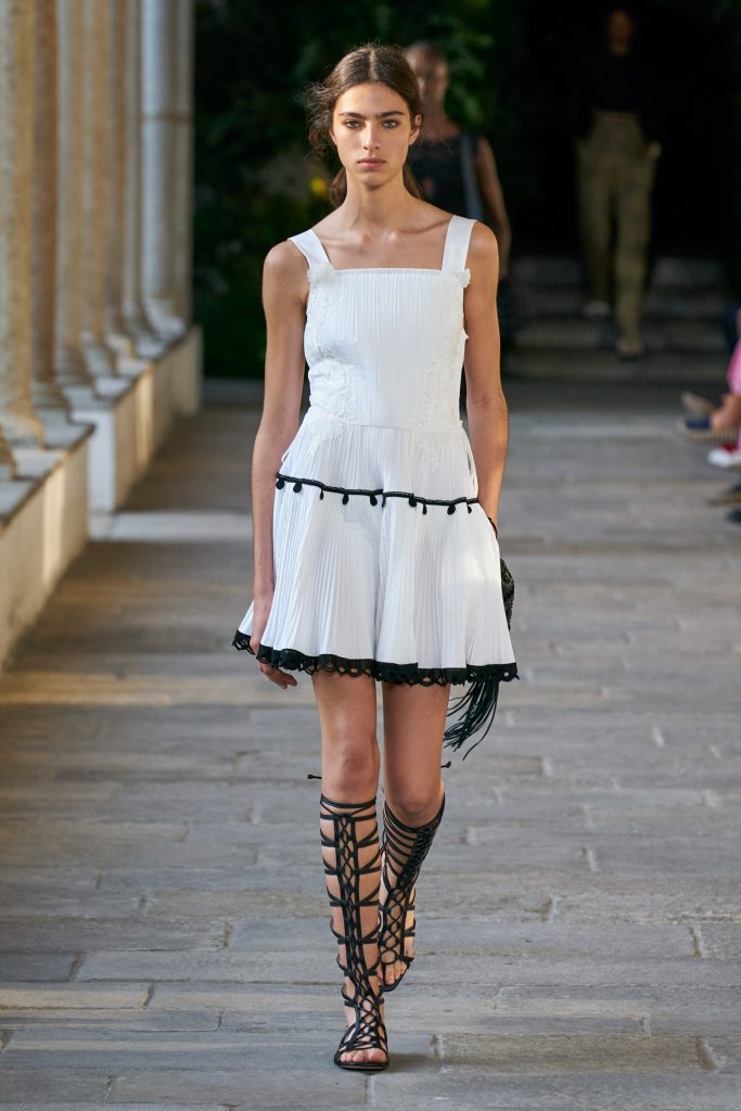 Foto de modelo desfilando Alberta Ferretti com sandália gladiadora e vestido boho.