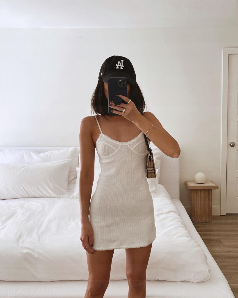 Foto de influenciadora com um vestido branco minimalista para o verão.